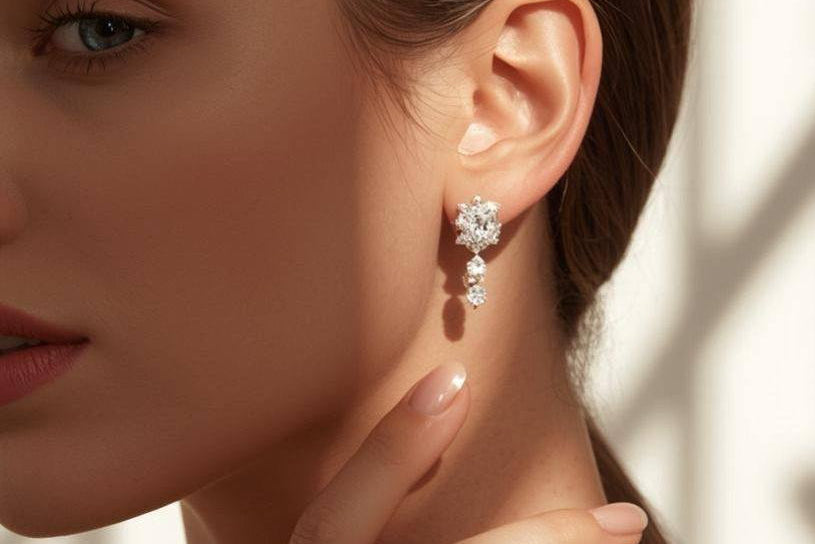 Woman wearing diamond earrings and ring with a soft background